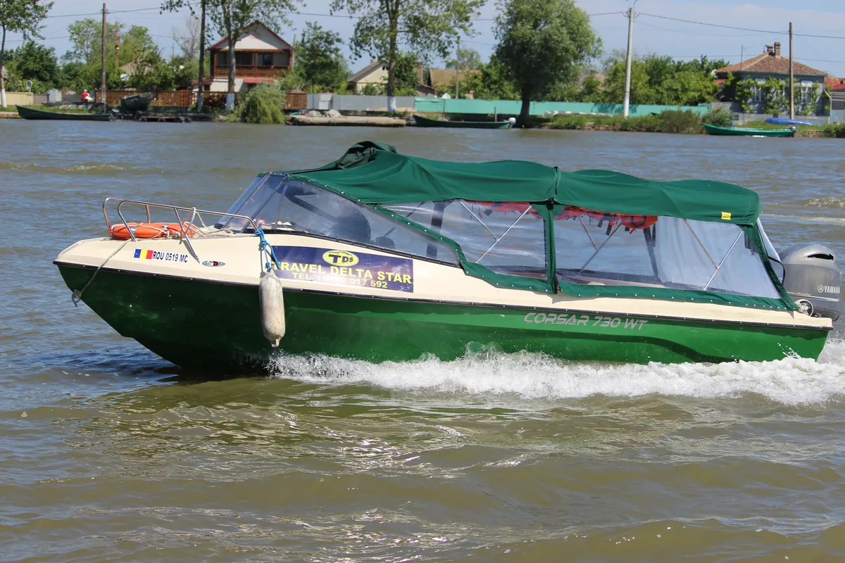 Travel Delta Star speedboat with a green canopy cruising on the Danube
